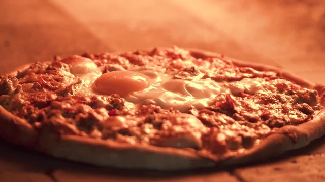 Delicious Arabic Traditional Baked Ramadan Lahmacun or Round Pide Bread with chicken egg on top cooking in rustic wood fired oven. Turkish pizza with minced beef or lamb meat, cheese and spices.