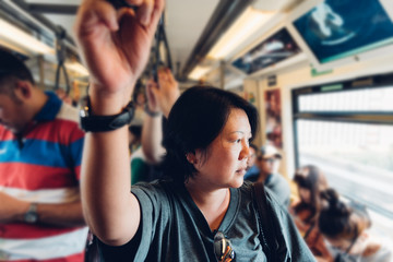 Asian woman travel on skytrain train in city