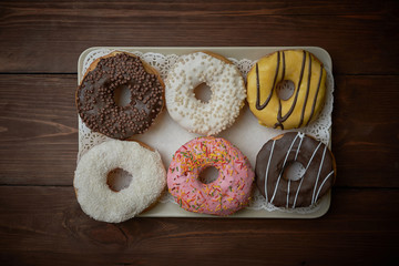 Multicolored donuts on a wooden table
