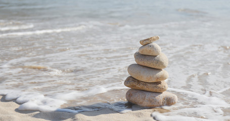 Fototapeta na wymiar Stack of several rocks on a pebble sea beach