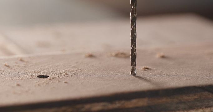 Electric driller on wooden plank