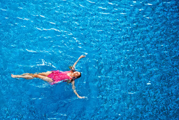 Top view of a woman floating in the pool