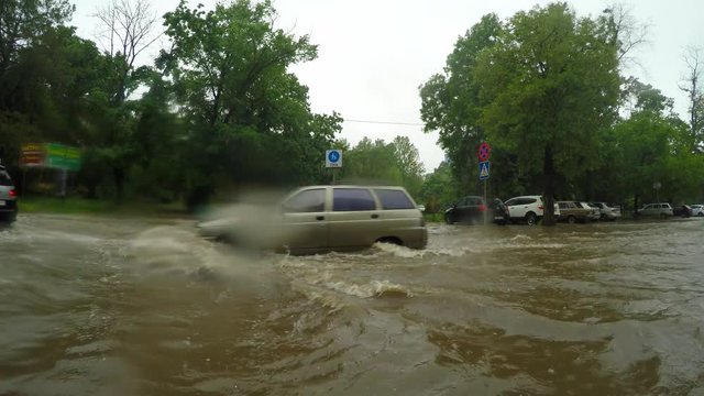 Cars drive on the road after heavy rain