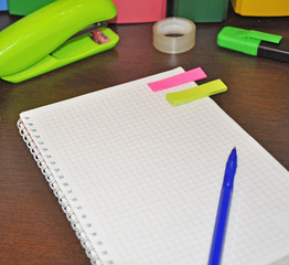 stationery for office, lying next to the notebook In the background are colorful binders