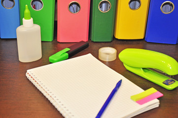 stationery for office, lying next to the notebook In the background are colorful binders