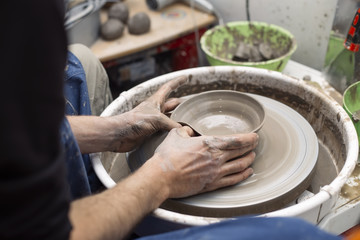 Artist makes clay pottery on a spin wheel