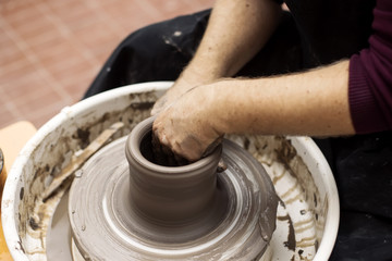 Artist makes clay pottery on a spin wheel