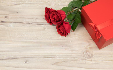 Red roses and gift box on wooden table, valentines Day, wedding day concept