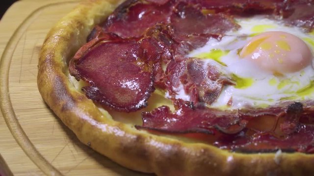 Turkish and Arabic Traditional Ramadan Food Pide or Pizza ingredients with Pastirma which is halal bacon, egg, mozzarella cheese, butter and spice on rustic white wood background. Rotating shot.