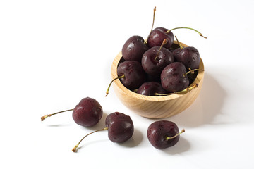 Fresh Cherrys in wooden bowl and falled out bowl on white background