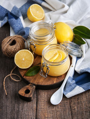 Lemon curd in glass jar with fresh lemons