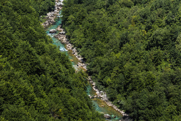 Fototapeta na wymiar Turquoise Tara River with yellow boat near Tara Canyon surrounded by green forest - aerial view suitable as background, Montenegro