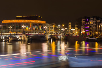 Stopera and Blue Bridge  crossing the Amstel river at night in the Amsterdam city center