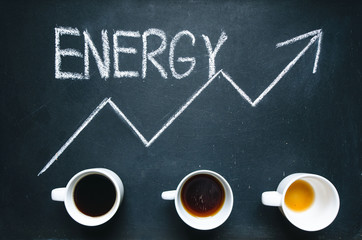 Fototapeta na wymiar Cups of coffee under the trend line. Move up of energy. Trend up of energy. Arrow and graph. Coffee on a blackboard. Concept of energy