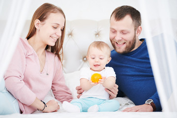 Parenting family. Mother and father playing with little newborn baby