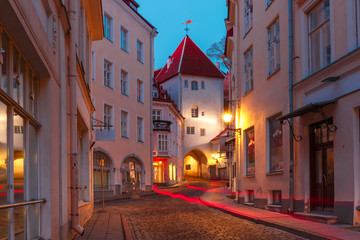 Beautiful illuminated medieval street in Old Town of Tallinn during evening blue hour, Estonia
