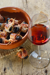 Leckere Tapas: Getrocknete Pflaumen in Speck gerollt und gebraten, dazu ein Glas Old Tawny Portwein – Delicious Spanish tapas:  Fried prunes wrapped in bacon served with Portuguese port wine