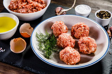 Raw meatballs on wooden background