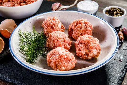 Raw meatballs on wooden background