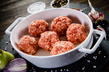 Raw meatballs on wooden background