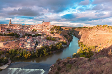 Naklejka premium Panoramic aerial view of Old city of Toledo with Cathedral, Alcazar and river Tajo at dusk, Castilla La Mancha, Spain