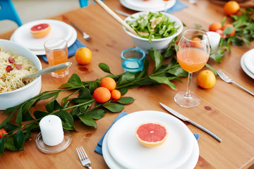 Served table with mandarins, grapefruits and cooked food prepared for guests