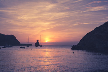 Fototapeta premium Quiet scene: Sailboats in a harbor at sunset. Mediterranean sea of Ibiza island