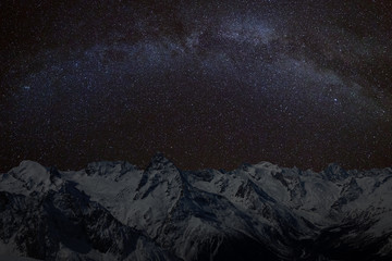 Mountain peaks in the background of the milky way. Night landscape with starry sky