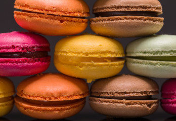Colorful macarons closeup on black background