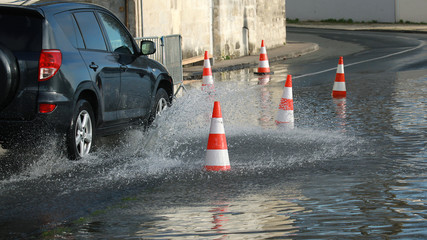 Voitures passant dans une rue inondée