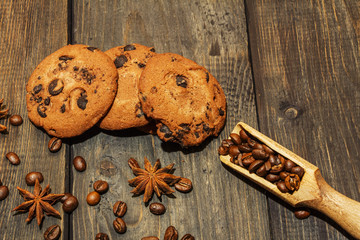 Delicious chocolate cookies with coffee beans, anise on a dark old wooden table.