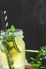 Cold lemonade mojito in a glass jar with lime and mint. Copy space.