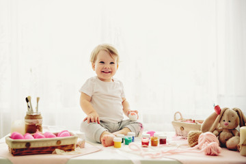 Obraz na płótnie Canvas little girl is painting eggs for Easter