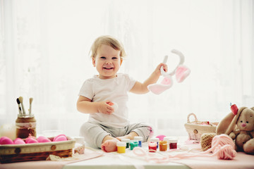 Obraz na płótnie Canvas little girl is painting eggs for Easter