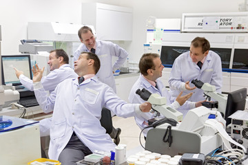 A group of identical doctors have fun in the lab. A team of researchers works by a hospital...