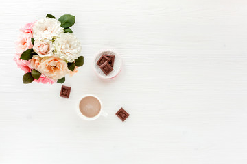Woman workspace with pink and yellow dahlias and roses flowers bouquet, accessories, diary, glasses on white background. Lay Flat home office desk. Top view feminine background.