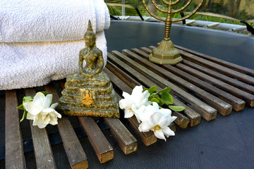 Obraz premium Thai Buddha made from pressed money with white flowers and a candlestick on a wooden lattice