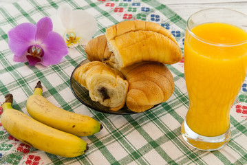 breakfast consist of croissants filled with chocolate bananas and orange juice with orchid aside breakfast in bed concept