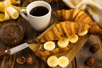 Croissants  with chocolate cream  and banana on the  wooden  cutting board