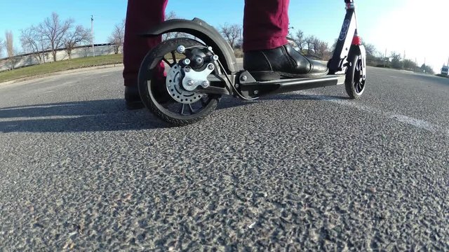 man is riding a scooter. A modern scooter. Disc brakes.