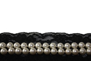 Beautiful top view detail of black lace and pearl beads on empty white background