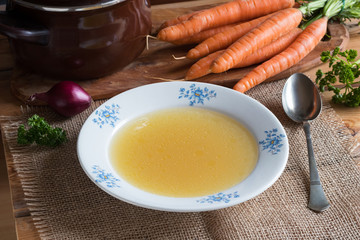 Chicken stock in a plate on a wooden table