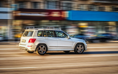 Obraz na płótnie Canvas A car moves along the street of a city. Blurred background. Motion blur