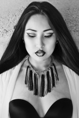 Black and white photo of model with long hair, bright make-up and accessories