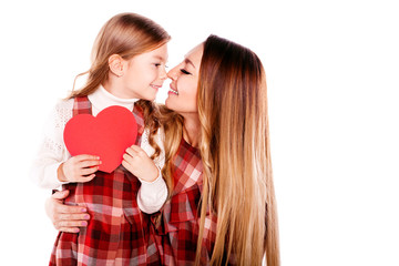 Happy smiling mother and daughter in red plaid dresses with paper Valentine heart isolated on a white background. Happy family. Happy Valentine's day. Happy mother's day. 