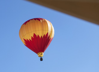 colorful hot air balloon descending near a house