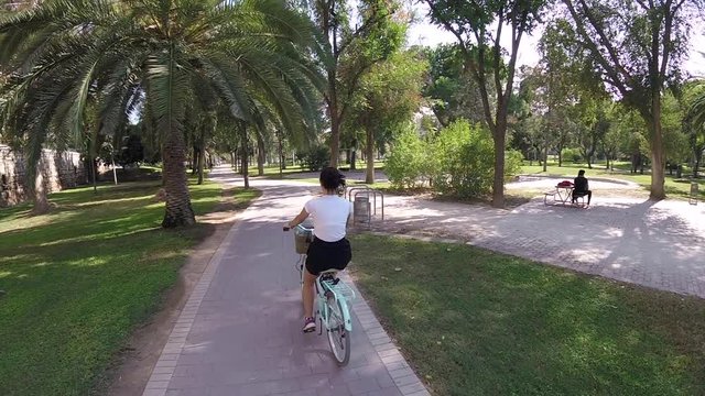 Attractive Young Brunette Girl Riding Rented Tourisctic Bicycle On Alley Of Turia River Park, Valencia, Spain, Europe, OCT 2017