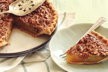 Close up of homemade Classic Pecan pie and a a slice on plate, selective focus