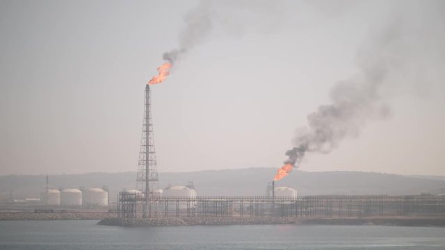 Burning gas waste on petrochemical refinery in haze
