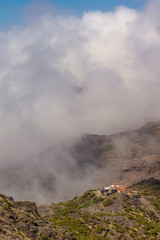 Dichte Wolken steigen auf über dem Haus in den Bergen
